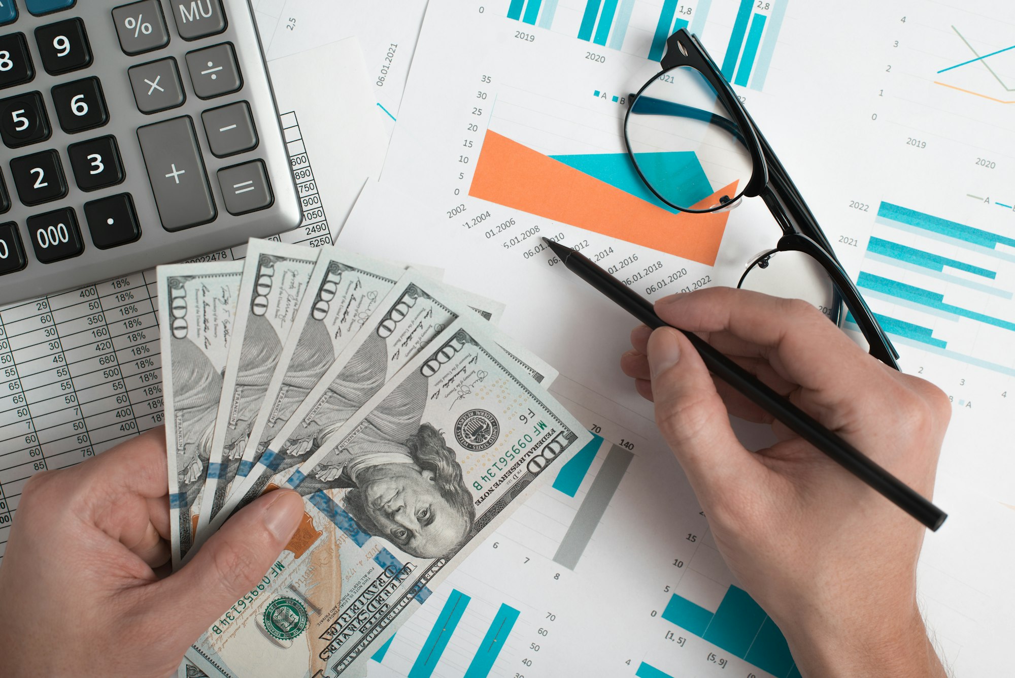 Business, finance and accounting. Close-up of an office worker's hand holding money and analyzing