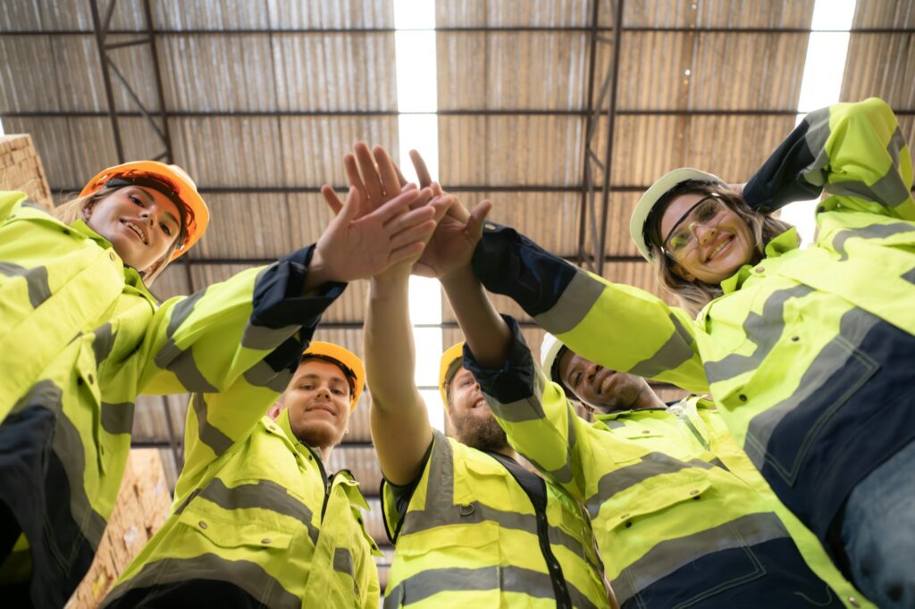 Portrait of happy workers giving high five at warehouse.